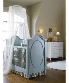 a baby crib in a room with white curtains