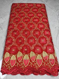 red and gold embroidered fabric with golden thread work on the edges, along with an intricate design