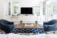 a living room filled with furniture and a flat screen tv mounted on the wall above a fireplace