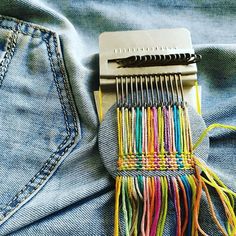 a pair of scissors sitting on the back of some blue jeans with multicolored pins sticking out of it