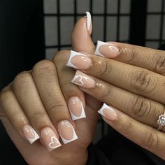 a woman's hands with french manies and white nail art designs on them