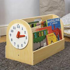 a wooden clock with books in it on the floor