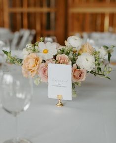 the table is set with flowers and place cards for guests to write their names on