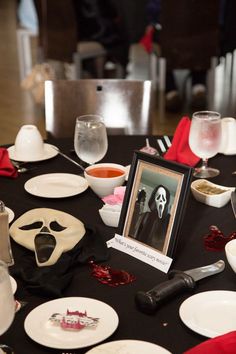 a table topped with white plates covered in halloween decorations