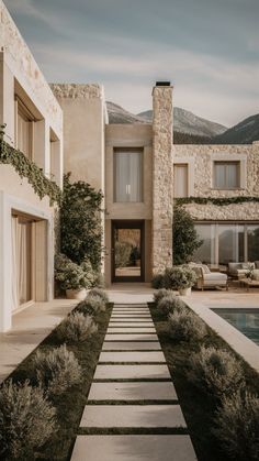 a house with a pool in front of it and stone steps leading up to the entrance