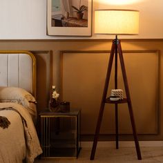 a bed room with a neatly made bed next to a night stand and a lamp