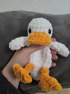 a person holding a stuffed duck in their hand