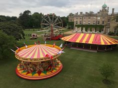 an aerial view of a fairground with people riding on the carousel and other rides