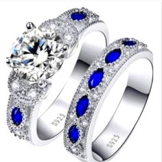 two wedding rings with blue and white stones on each side, one has an oval cut diamond