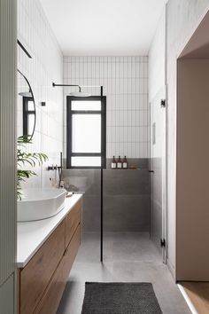 a bathroom with a sink, mirror and shower in it's center wall is shown