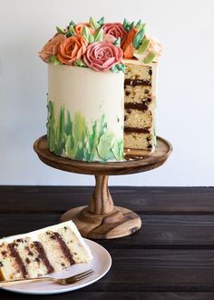 there is a cake with flowers on it and a piece of cake next to it