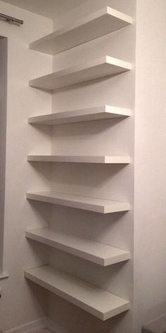 a white shelf in the corner of a room