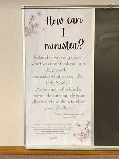 a sign that is hanging on the side of a wall next to a window with flowers