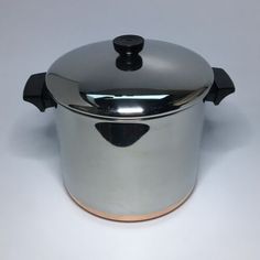 a stainless steel pot with a lid on a white background