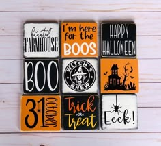 halloween magnets are arranged in the shape of squares on a white wooden background with black and orange lettering