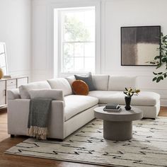 a living room filled with furniture and a white rug on top of a hard wood floor