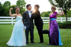 four people in formal wear posing for the camera