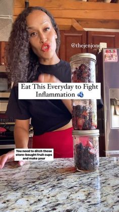 a woman standing in front of a jar filled with food