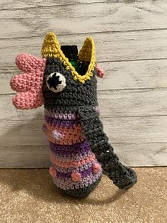 a crocheted bottle holder with a stuffed animal in the top and bottom part