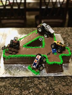 a birthday cake with cars on it sitting on a table