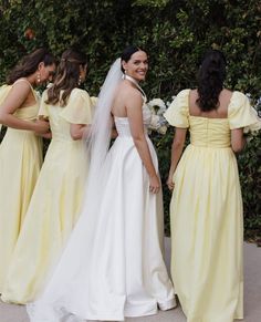 four bridesmaids in yellow dresses are standing next to each other