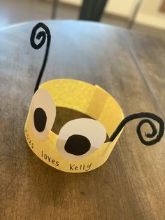 a paper crown with the words love's kelly on it sitting on top of a wooden table