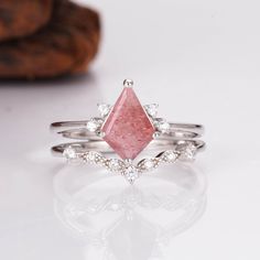 This enchanting piece features a genuine strawberry quartz gemstone, its soft pink hue reminiscent of summer berries. Sparkling inclusions dance within the stone, adding a touch of playful charm. The unique kite-shaped design is complemented by delicate, shimmering accents, creating an elegant and timeless look. Perfect for those who seek a blend of sophistication and whimsical beauty, this ring set is a true statement of individuality. ✦ DETAILS ✦✧ Handcrafted ✧ 1.25 Carat center stone✧ Strawbe Morganite Teardrop Jewelry Gift, Teardrop Morganite Jewelry Gift, Pink Rings With Natural Stones For Anniversary, Pink Faceted Ring Jewelry, Pink Stackable Crystal Ring As Gift, Stackable Pink Crystal Ring As Gift, Pink Stackable Crystal Ring For Gift, Pink Stackable Crystal Ring Gift, Pink Natural Stones Ring Jewelry