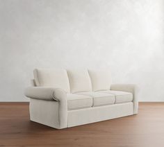 a white couch sitting on top of a wooden floor