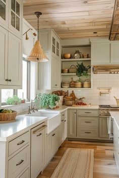 a kitchen filled with lots of white cabinets and counter top space next to a window