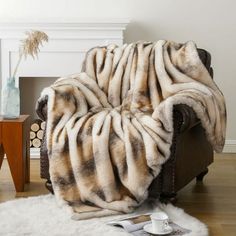 a chair with a blanket on top of it in front of a fire place and fireplace