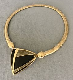 "You are looking at a truly exquisite VINTAGE TRIFARI MODERNIST, ART DECO STYLE, KUNIO MATSUMOTO ERA, BLACK and SILVER-COLOURED ENAMEL AND GOLD METAL OMEGA SNAKE CHAIN PENDANT COLLAR NECKLACE, SIGNED, Circa 1980's. THIS COLLAR NECKLACE IS EXTREMELY BOLD, EYE-CATCHING AND GORGEOUS SUPER RARE MINT, IN EXCELLENT, LIKE NEW CONDITION, IT HAS NEVER BEEN USED THIS NECKLACE WITH AN ART DECO INSPIRED BLACK AND SILVER ENAMEL STATION AND SUPER SHINY OMEGA CHAIN IS EXTRAORDINARILY BEAUTIFUL AND SCULPTURAL T Elegant Black Enamel Necklaces For Evening, Elegant Evening Necklaces With Black Enamel, Elegant Evening Black Enamel Necklaces, Elegant Evening Necklace With Black Enamel, Modern Gold Necklace With Black Enamel, Formal Gold Necklace With Unique Design, Unique Metal Necklaces For Formal Occasions, Vintage Black Enamel Necklaces For Formal Occasions, Vintage Black Enamel Necklaces For Evening