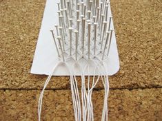 a close up of a hair comb on a table with white string attached to it