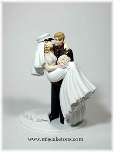 a figurine of a bride and groom holding each other in their arms, on a white background