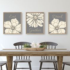 a dining room table with four chairs and two pictures on the wall above it that say eat drink gather