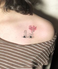 a woman's shoulder with a small tattoo on the left side of her chest