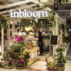 the inside of a flower shop with flowers on display