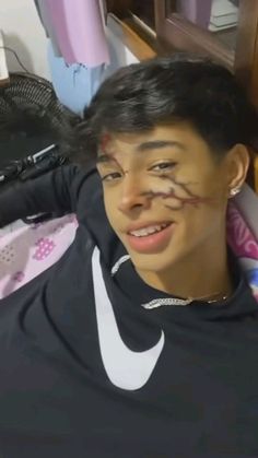 a young woman with her face painted in the shape of a nike t - shirt