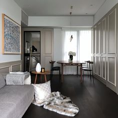 a living room filled with furniture next to a dining room table and chairs on top of a hard wood floor