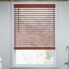 a bathroom window with wooden blinds in it