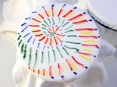 a white object with multicolored crayons painted on it's surface