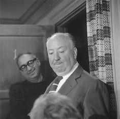 an old black and white photo of two men looking at something in front of them