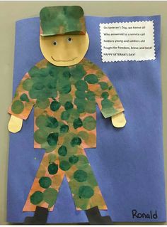 a child's handmade paper cut out of a soldier with green leaves on it