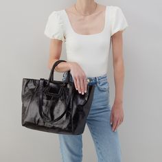 This bag has everything you want in a tote: top zip closure, a padded tech pocket, solid leather straps, and Sheila's signature circular handles that fold down when not in use! Sleek Travel Shoulder Bag With Leather Handles, Sleek Bags With Detachable Strap For Shopping, Sleek Shoulder Bag With Detachable Handle For Shopping, Sleek Shopping Bags With Detachable Handle, Sleek Shopping Bag With Detachable Handle, Sleek Satchel With Detachable Handle In Tote Shape, Versatile Satchel With Leather Handles For Shopping, Versatile Shopping Satchel With Leather Handles, Sleek Tote Satchel With Detachable Handle