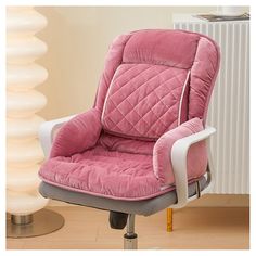 a pink office chair sitting on top of a wooden floor next to a white radiator