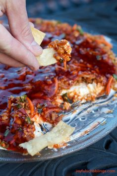 a person is dipping some food into a pizza crust with sauce and cheese on top