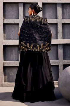 Black cape with floral embroidery and tassel detailing. Paired with pre-draped lehenga saree and embroidered blouse.
Components: 3
Pattern: Embroidered
Type Of Work: Floral
Neckline: Square
Sleeve Type: Cape sleeves
Fabric: Georgette, viscose satin organza
Color: Black
Other Details: 
Layered detailing
Cutout detailing
Gathered detailing
Occasion: Wedding - Aza Fashions Draped Lehenga, Sarees Black, Drape Lehenga, Floral Cape, Black Cape, Lehenga Saree, Cape Sleeves, Fashion App, Embroidered Blouse