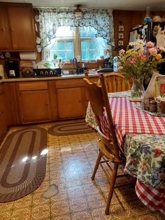 a kitchen with a table and chairs covered in checkered cloths next to a window