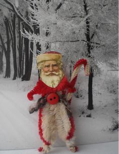 a santa clause holding a candy cane in the snow