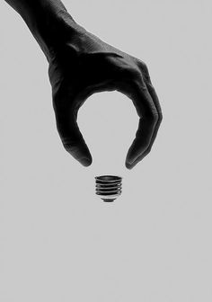 a person's hand reaching out towards a stack of coins on a white background