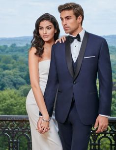 a man and woman in formal wear posing for a photo